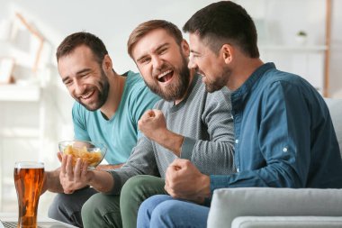 Evdeki spor bahislerini kazandıktan sonra mutlu adamlar.