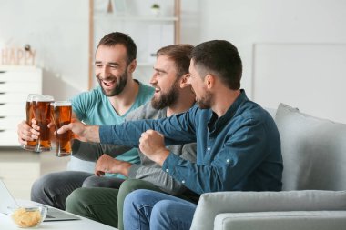 Evdeki spor bahislerini kazandıktan sonra mutlu adamlar.