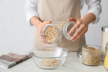 Kadın mutfakta yulaf lapası pişiriyor.