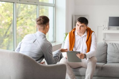 Ofiste genç bir çocukla çalışan psikolog.