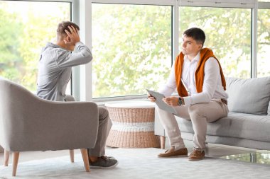 Ofiste genç bir çocukla çalışan psikolog.