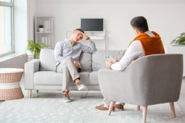 Ofiste genç bir çocukla çalışan psikolog.