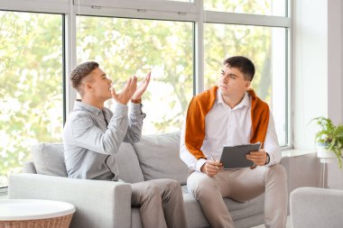 Ofiste genç bir çocukla çalışan psikolog.