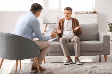 Psikoloğun muayenehanesindeki genç çocuk.