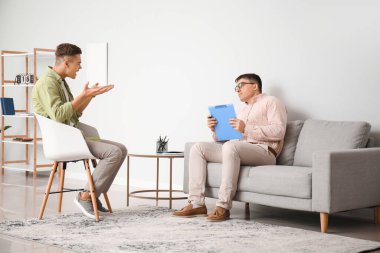 Ofiste genç bir çocukla çalışan psikolog.