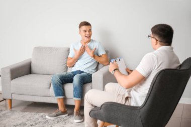 Psikoloğun muayenehanesindeki genç çocuk.