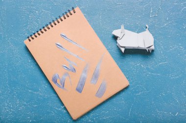 Origami boğası 2021 yılının sembolü ve renk arkaplanı üzerine not defteri