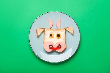 Arka planda boğa şeklinde lezzetli bir sandviç tabağı.