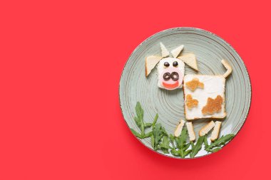 Arka planda boğa şeklinde lezzetli bir sandviç tabağı.