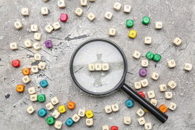 Grunge arkaplanında büyüteçle SEO kısaltması