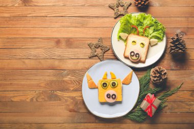 Boğa şeklinde lezzetli sandviçler ve ahşap arka planda yeni yıl dekorasyonu.