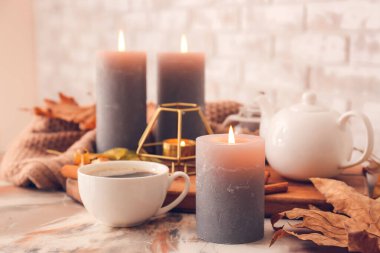 Güz yapraklı güzel aroma mumları ve masada kahve.