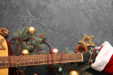 Karanlık arka planda Noel dekoru olan gitar