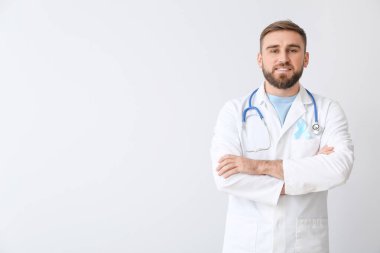 Açık arkaplanda mavi kurdeleli bir doktor. Prostat kanseri farkındalığı