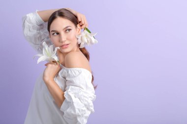 Renkli zambakları olan genç ve güzel bir kadın.