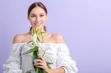 Renkli zambakları olan genç ve güzel bir kadın.