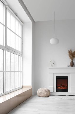 İçinde şömine ve puf olan bir oda.