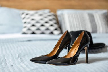 Yatakta siyah yüksek topuklu ayakkabılar