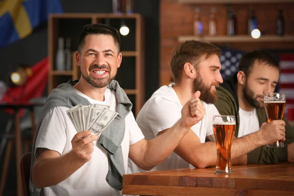 Bardaki spor bahsini kazandıktan sonra mutlu bir adam.