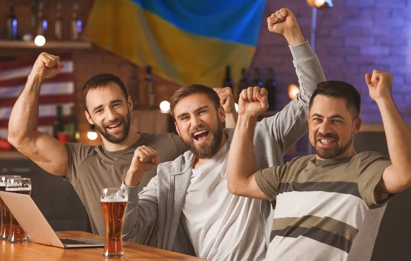 Bardaki spor bahislerini kazandıktan sonra mutlu adamlar.