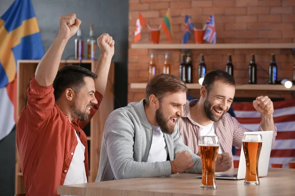 Bardaki spor bahislerini kazandıktan sonra mutlu adamlar.