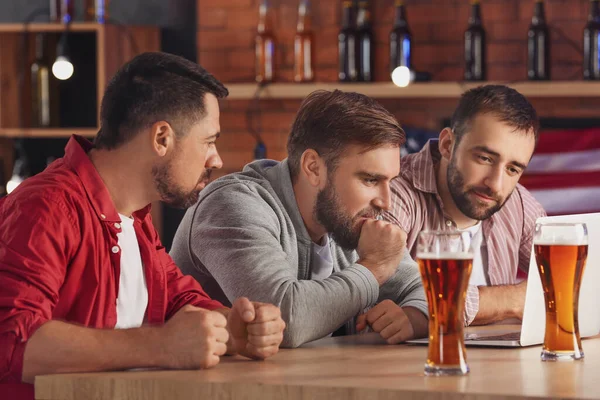 Men placing sports bets in pub