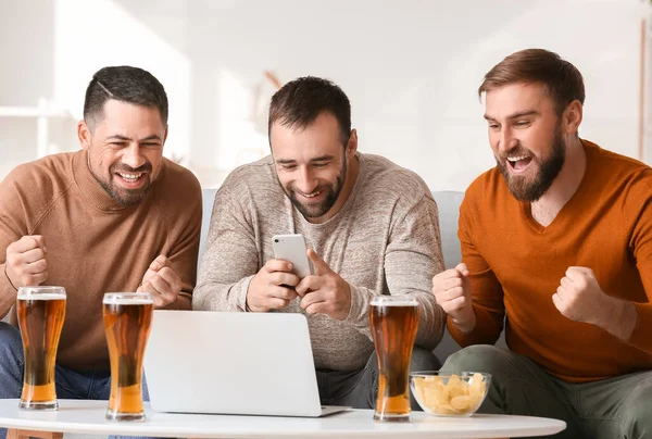 Evdeki spor bahislerini kazandıktan sonra mutlu adamlar.