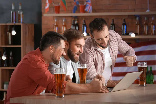 Bardaki spor bahislerini kazandıktan sonra mutlu adamlar.