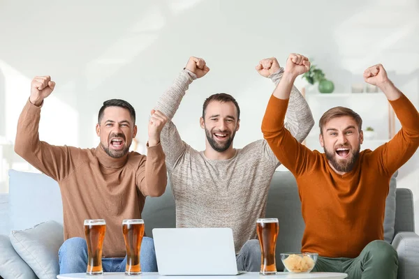 Evdeki spor bahislerini kazandıktan sonra mutlu adamlar.