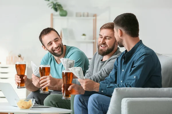 Evdeki spor bahislerini kazandıktan sonra mutlu adamlar.