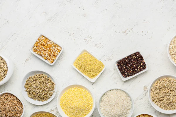 Beyaz arka planda tahıl çeşitleri içeren kaseler