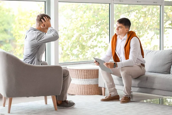 Ofiste genç bir çocukla çalışan psikolog.