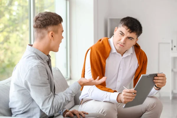 Ofiste genç bir çocukla çalışan psikolog.