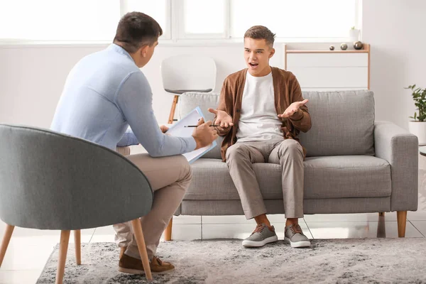 Psikoloğun muayenehanesindeki genç çocuk.