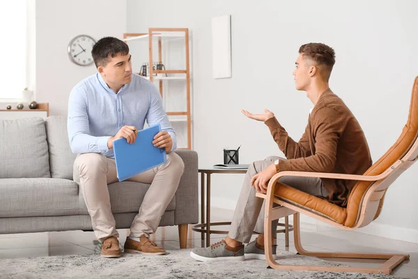 Ofiste genç bir çocukla çalışan psikolog.