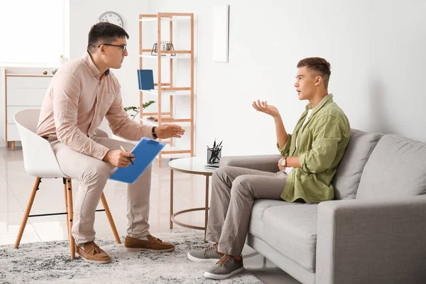 Ofiste genç bir çocukla çalışan psikolog.