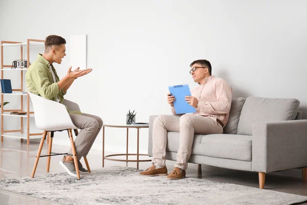 Ofiste genç bir çocukla çalışan psikolog.