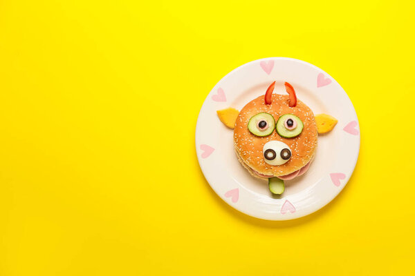 Plate with tasty sandwich in shape of bull on color background