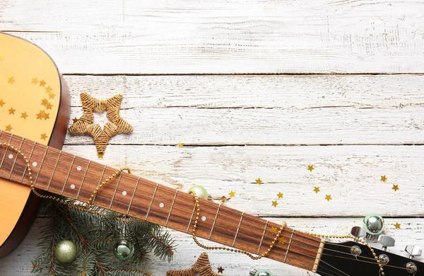 白い木製の背景にクリスマスの装飾が施されたギター — ストック写真