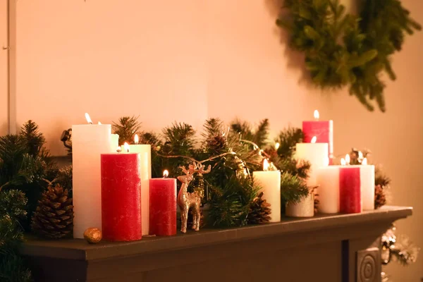 クリスマスのために装飾されたマントルピースの上にろうそくを燃やす — ストック写真
