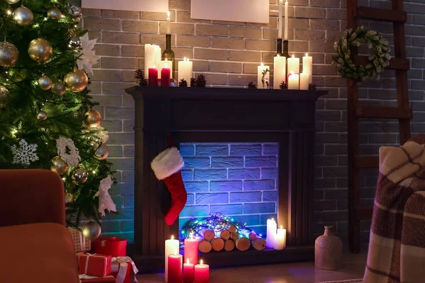 Burning candles in interior of living room decorated for Christmas
