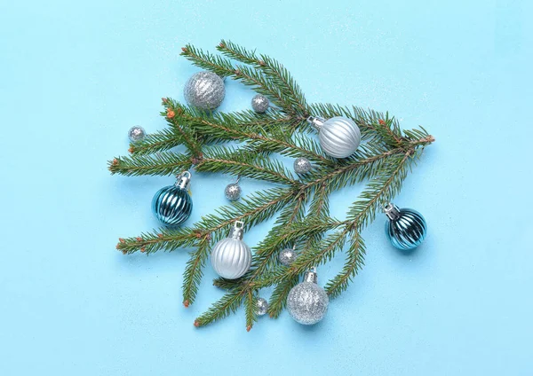 Renkli arkaplanda güzel Noel topları olan fidan dalı