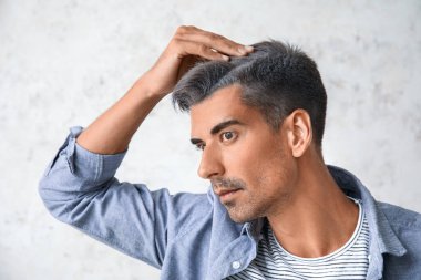 Açık arkaplanda kır saçlı bir adam.