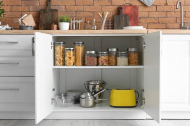 Mutfak eşyalı raflar ve dolaplı cam kavanozlar.