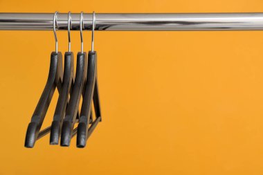 Renk arkaplanında elbise askısı olan dizin