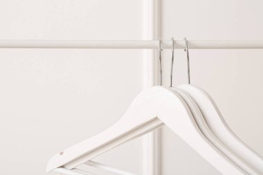 Beyaz arkaplanda elbise askıları ile dizin