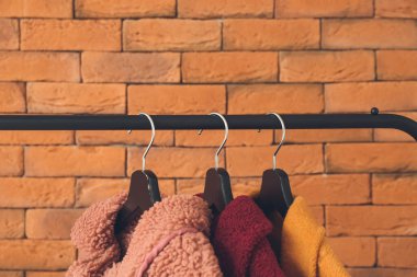 Tuğla duvarın yanında giysilerle dizilin.