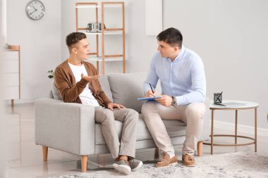 Ofiste genç bir çocukla çalışan psikolog.