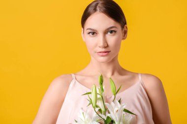 Renkli zambakları olan genç ve güzel bir kadın.