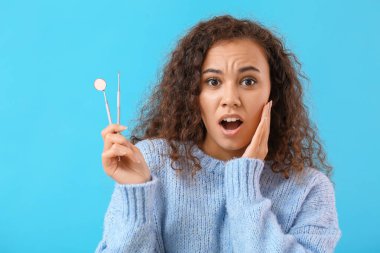 Geçmişinde dişçi aletleri olan stresli genç bir kadın.